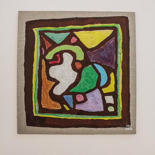 An abstract geometric painting on a square canvas, featuring a colorful design with green, yellow, purple, blue, brown, and white shapes, mounted on a light gray textured wall.